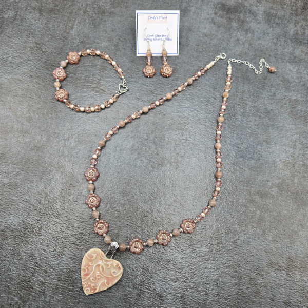 Pink heart pendant on floral theme chain.